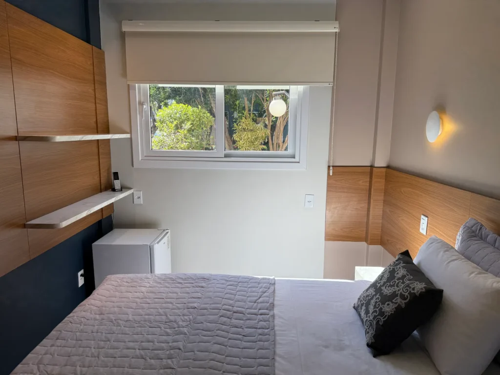 Bancada de trabalho junto à janela, ao lado da cama