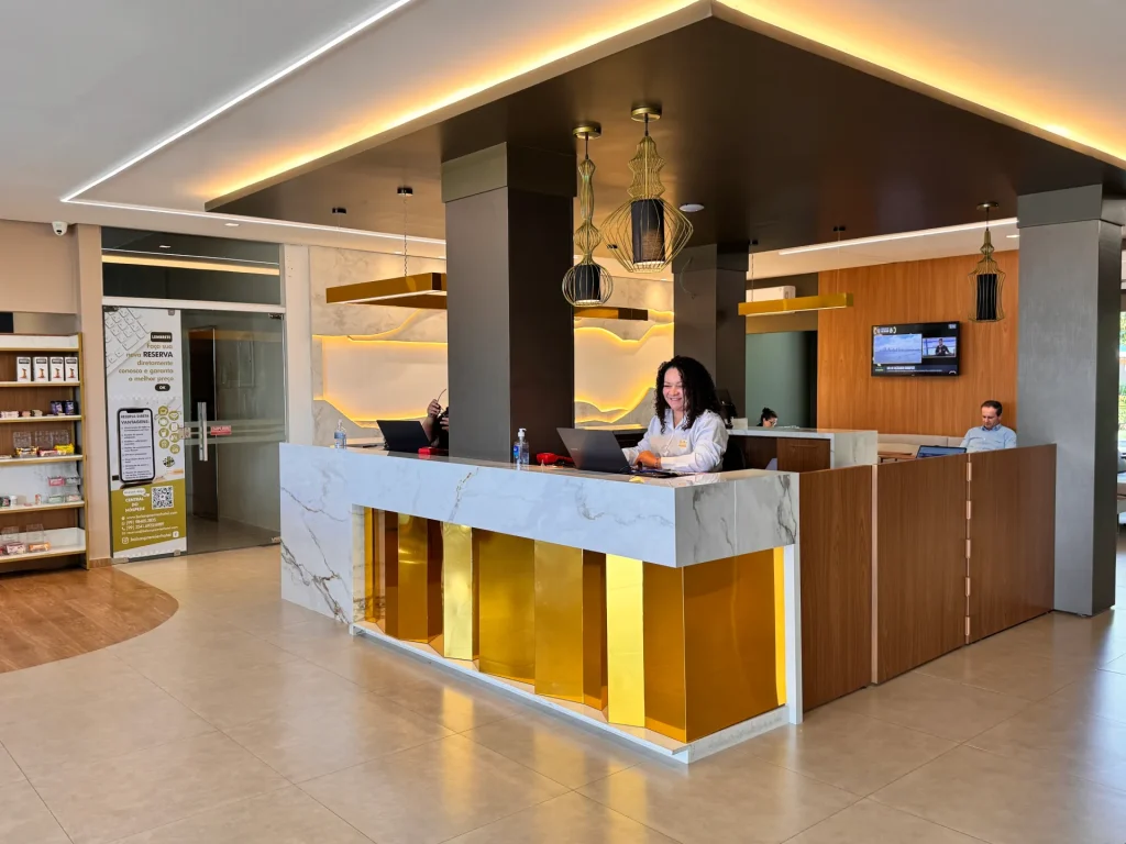 Recepção do Balsas Premier Hotel, com balcão de mármore e painéis dourados retroiluminados