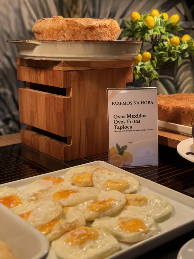 Travessa de ovos fritos ao lado da placa "Fazemos na hora: ovos mexidos, ovos fritos e tapioca".
