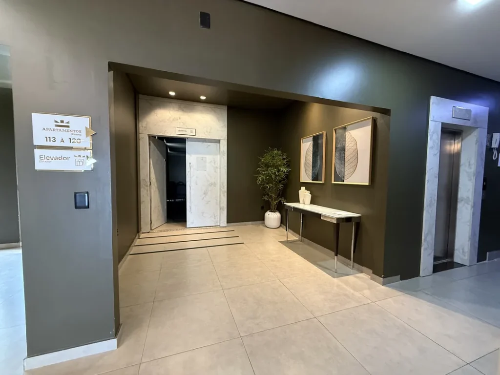 Hall de acesso ao Auditório Premier, com elevador e parede revestida de mármore